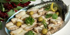 pieces of boiled sturgeon, decorated with olives and herbs