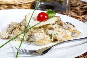 Tender tench in the oven in sour cream with mushrooms