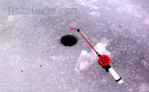 The fishing rod is equipped with a bright nod, noticeable in the snow.