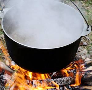 Pike soup in a cauldron on a fire
